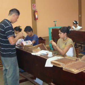 Supervisor checking freshly rolled cigars